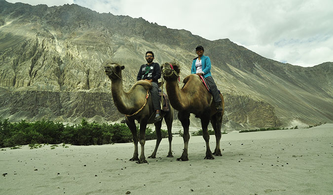 Vikram e Ishwinder do Empty Rusacks sentam em camelos e posam para uma foto
