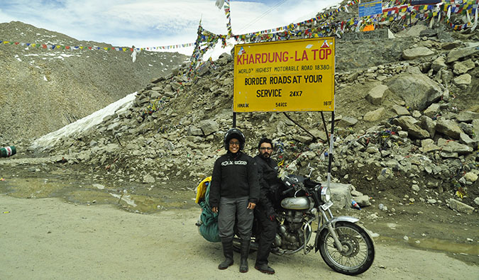 Vikram e Ishwinder de Empty Rusacks posam em uma motocicleta perto da montanha