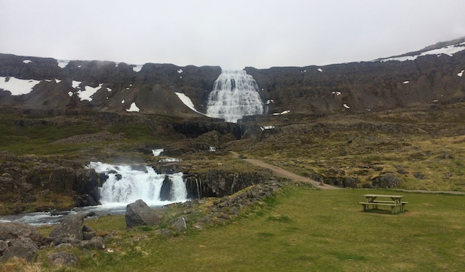 Cachoeira solitária, cortando os penhascos dos pranchas de oeste, Islândia