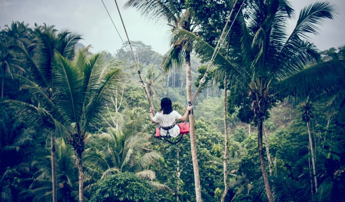 O solitário-viajante de mulher em um balanço na selva em Bali < pan> segura minha viagem (para aqueles por 70)