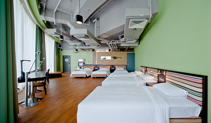 Sala de estar ampla e espaçosa com camas de casal e de solteiro e mesa longa no Y Loft, Hong Kong