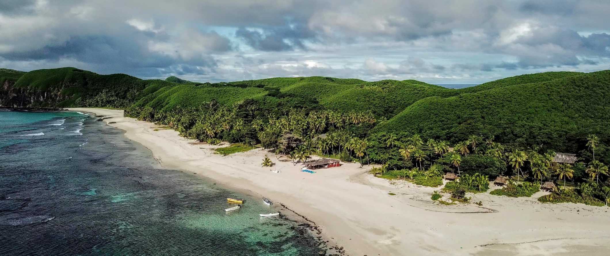 Vista do ar para a praia e uma magnífica selva verde na costa das Ilhas Yasawa em Fiji