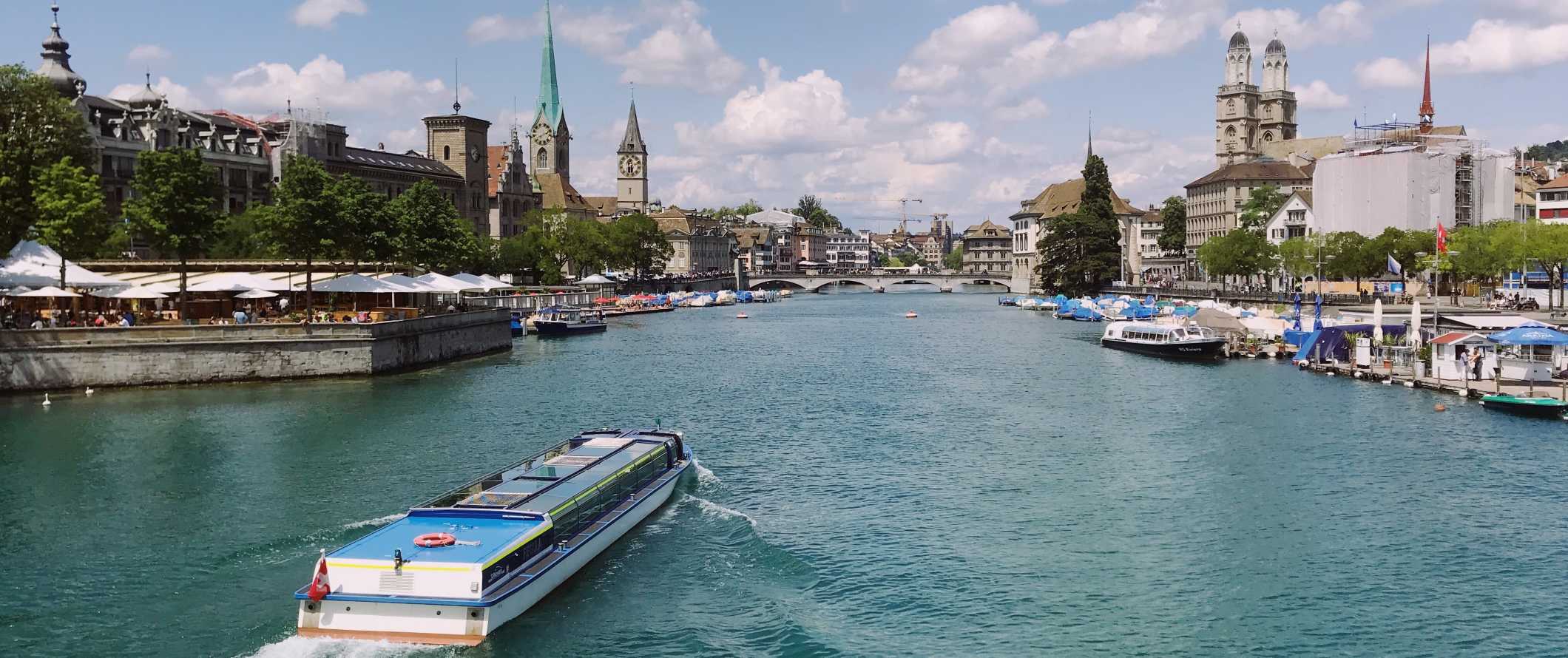 O barco desce ao longo do rio em Zurique, na Suíça